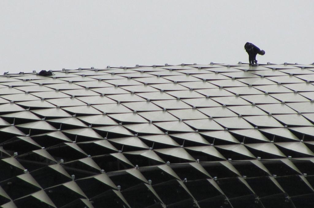 Man Working on Very High Roof by John Morgan